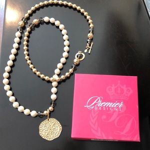 Long beaded costume gold necklace with pendant.